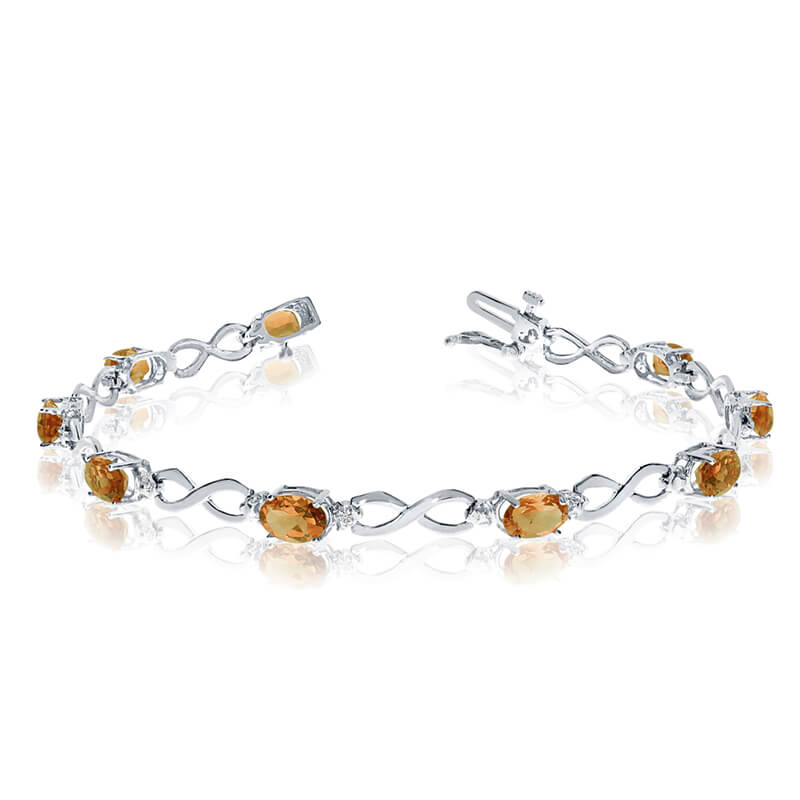 This 10k white gold oval citrine and diamond bracelet features nine 6x4 mm stunning natural citri...