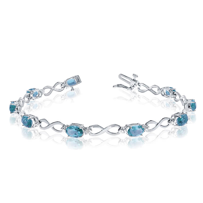 This 14k white gold oval blue topaz and diamond bracelet features nine 6x4 mm stunning natural bl...