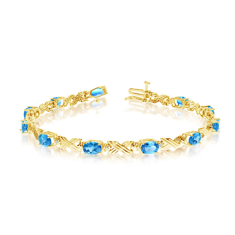 This 10k yellow gold oval blue topaz and diamond bracelet features eleven 6x4 mm stunning natural...