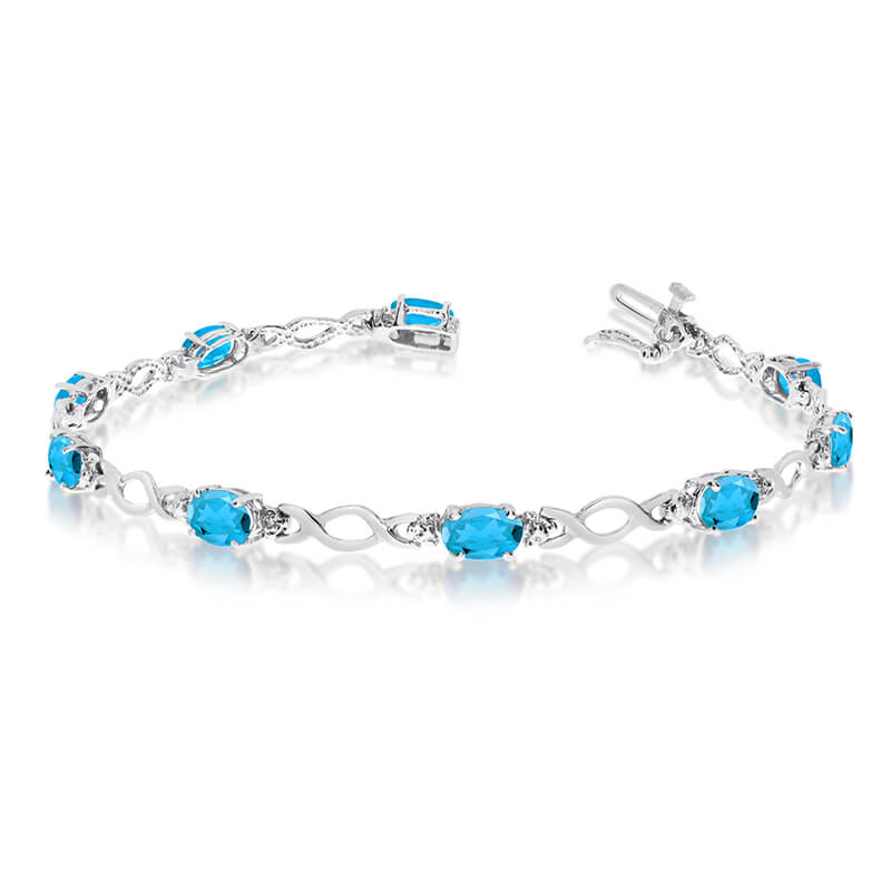 This 10k white gold oval blue topaz and diamond bracelet features ten 6x4 mm stunning natural blu...