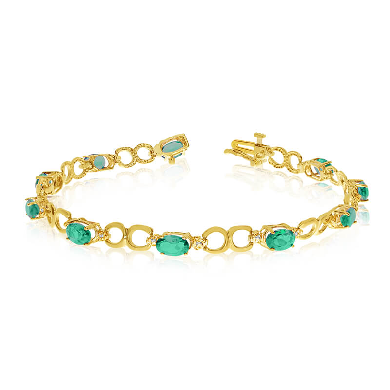 This 10k yellow gold oval emerald and diamond bracelet features ten 6x4 mm stunning natural emera...