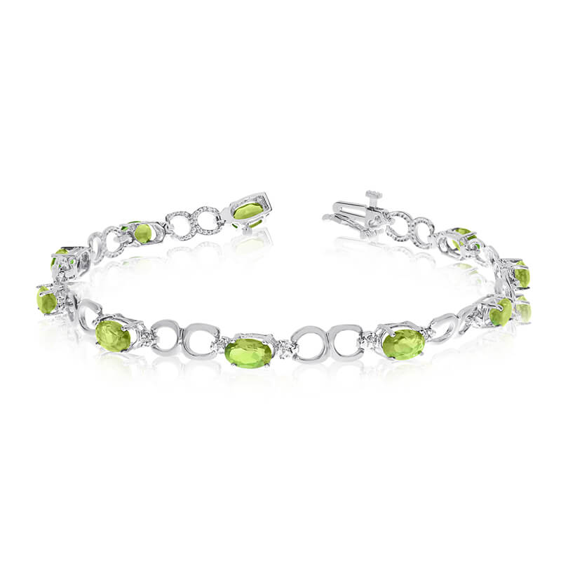 This 10k white gold oval peridot and diamond bracelet features ten 6x4 mm stunning natural perido...