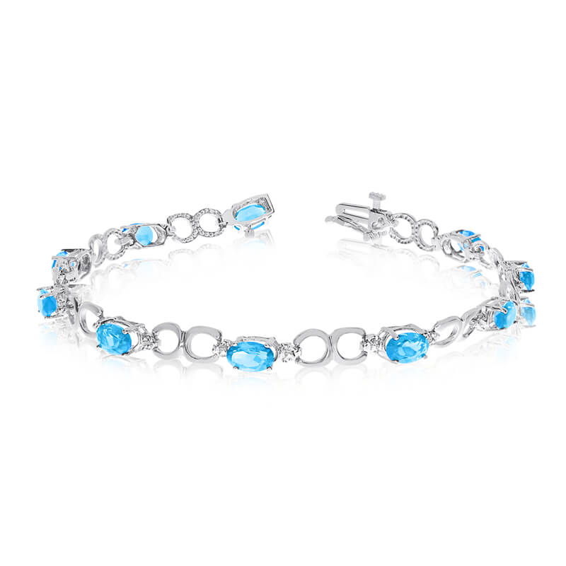 This 14k white gold oval blue topaz and diamond bracelet features ten 6x4 mm stunning natural blu...