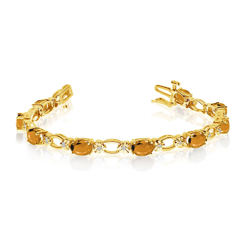 This 14k yellow gold natural citrine and diamond tennis bracelet features 12 oval citrines with a...