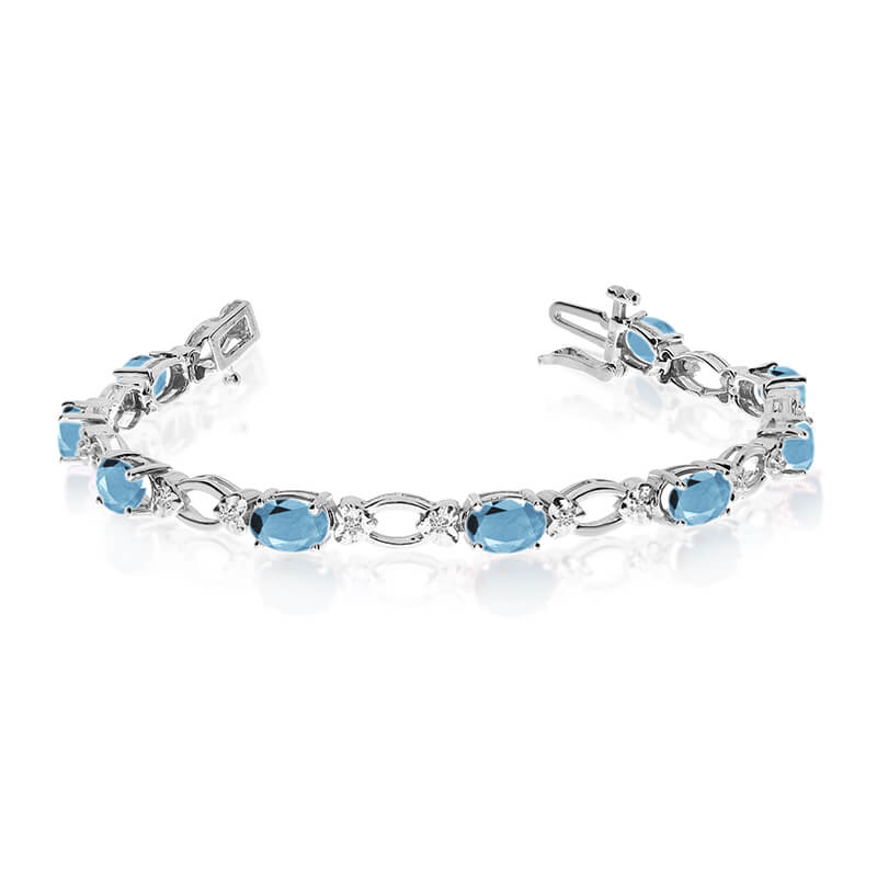 This 14k white gold natural aquamarine and diamond tennis bracelet features 12 oval aquamarines w...