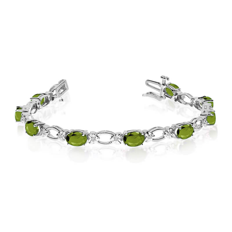 This 14k white gold natural peridot and diamond tennis bracelet features 12 oval peridots with a total gem weight of 4.8 carats and a total diamond weight of 0.12 carats.