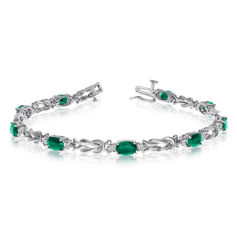 This 14k white gold natural emerald and diamond tennis bracelet features 9 oval emeralds with a t...