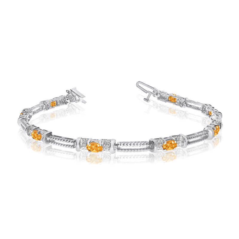This 14k white gold natural citrine and diamond tennis bracelet features 8 oval citrines with a t...