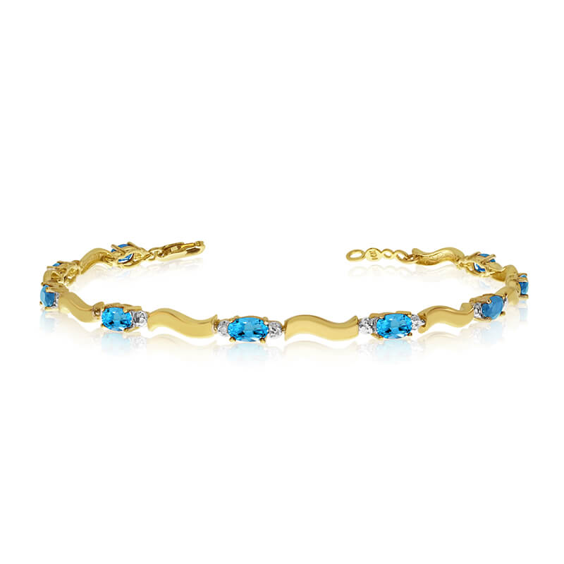 This 10K Yellow Gold oval blue topaz and diamond bracelet features nine 5x3 mm stunning natural b...