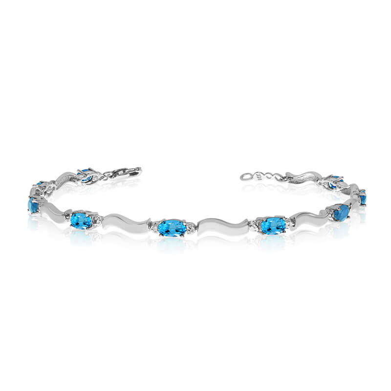 This 10K White Gold oval blue topaz and diamond bracelet features nine 5x3 mm stunning natural bl...