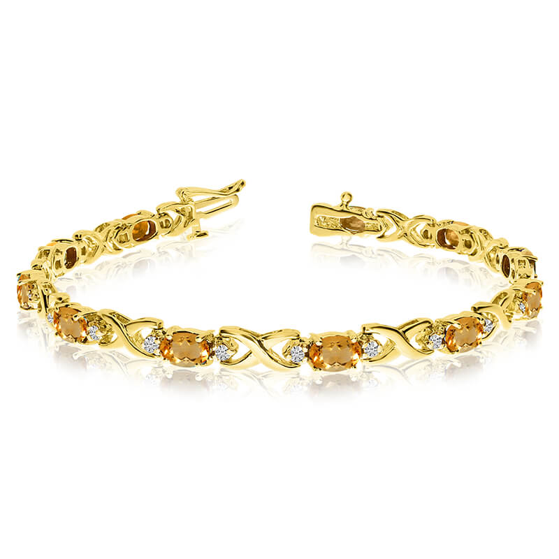 This 14k yellow gold natural citrine and diamond tennis bracelet features 11 oval citrines with a...