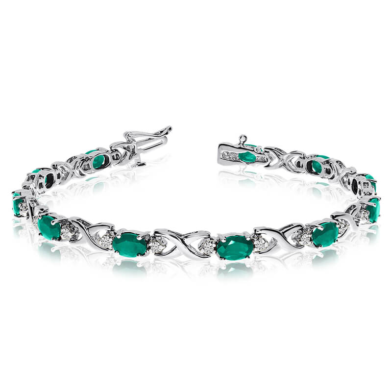 This 14k white gold natural emerald and diamond tennis bracelet features 11 oval emeralds with a ...