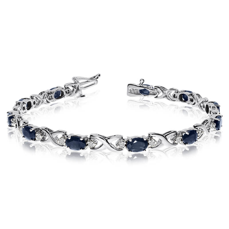 This 14k white gold natural sapphire and diamond tennis bracelet features 11 oval sapphires with ...