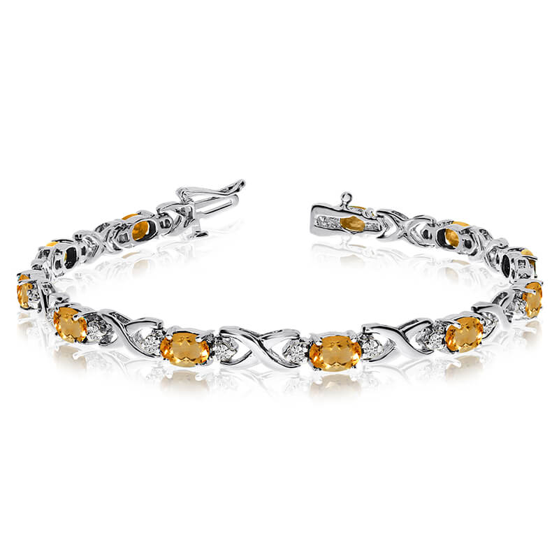 This 14k white gold natural citrine and diamond tennis bracelet features 11 oval citrines with a ...