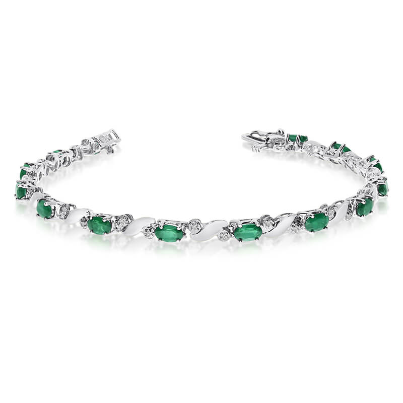 This 14k white gold natural emerald and diamond tennis bracelet features 13 oval emeralds with a ...